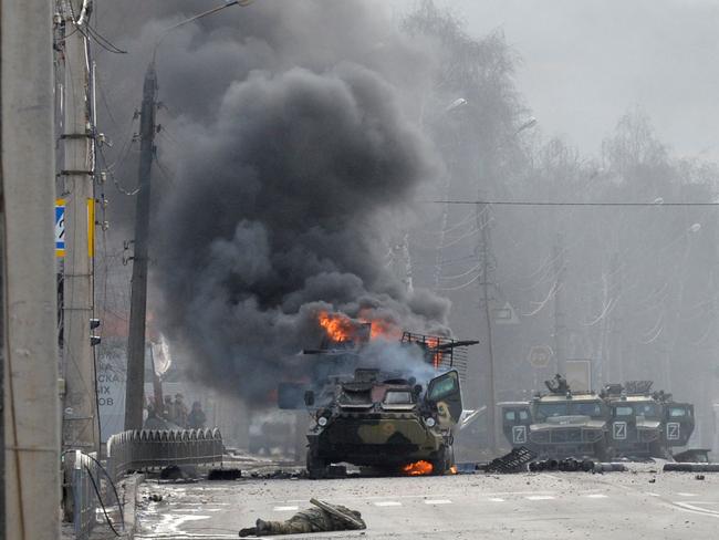 A Russian Armoured personnel carrier (APC) burning next to unidentified soldier's body during fight with the Ukrainian armed forces in Kharkiv. Picture: AFP