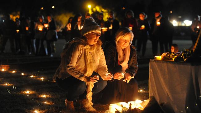 Members of the community lay candles at a gathering to support the family of Qi Yu in Berowra. Picture: Jake McCallum