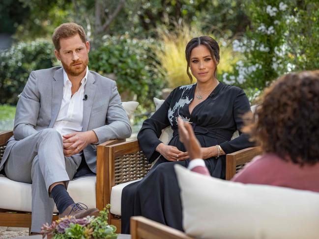 This undated image released March 7, 2021 courtesy of Harpo Productions shows Britain's Prince Harry (L) and his wife Meghan (C), Duchess of Sussex, in a conversation with US television host Oprah Winfrey. - Britain's royal family on March 7, 2021 braced for further revelations from Prince Harry and his American wife, Meghan, as a week of transatlantic claim and counter-claim reaches a climax with the broadcast of their interview with Oprah Winfrey. The two-hour interview with the US TV queen is the biggest royal tell-all since Harry's mother princess Diana detailed her crumbling marriage to his father Prince Charles in 1995. (Photo by Joe PUGLIESE / HARPO PRODUCTIONS / AFP) / RESTRICTED TO EDITORIAL USE - MANDATORY CREDIT "AFP PHOTO/ HARPO PRODUCTIONS -  Joe PUGLIESE" - NO MARKETING NO ADVERTISING CAMPAIGNS - DISTRIBUTED AS A SERVICE TO CLIENTS --- NO ARCHIVE ---