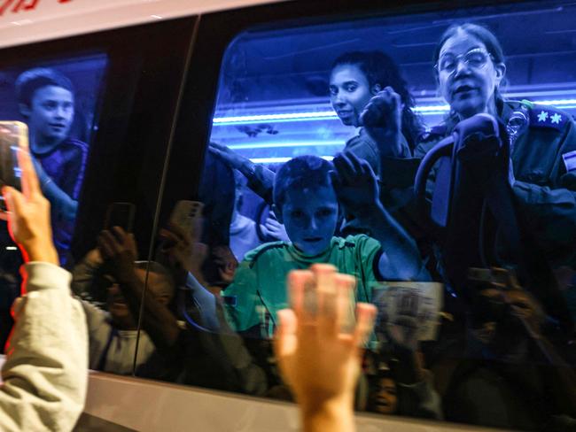 Hostages released by Hamas wave to the crowd from a vehicle driving towards an army base in Ofakim on November 26. Picture: AFP