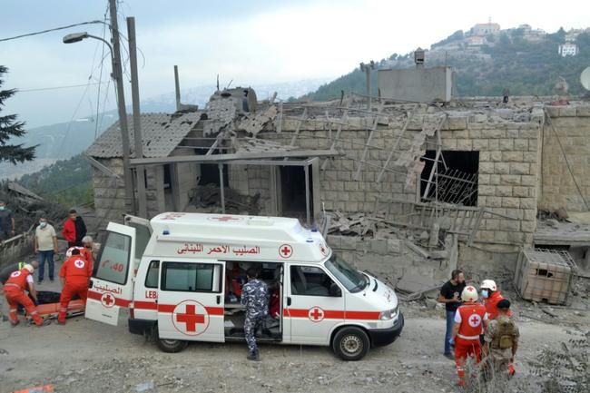 Lebanese Red Cross paramedics transport a body unearthed from the rubble at the site of an Israeli air strike that targeted the northern Lebanese village of Aito on October 14, 2024