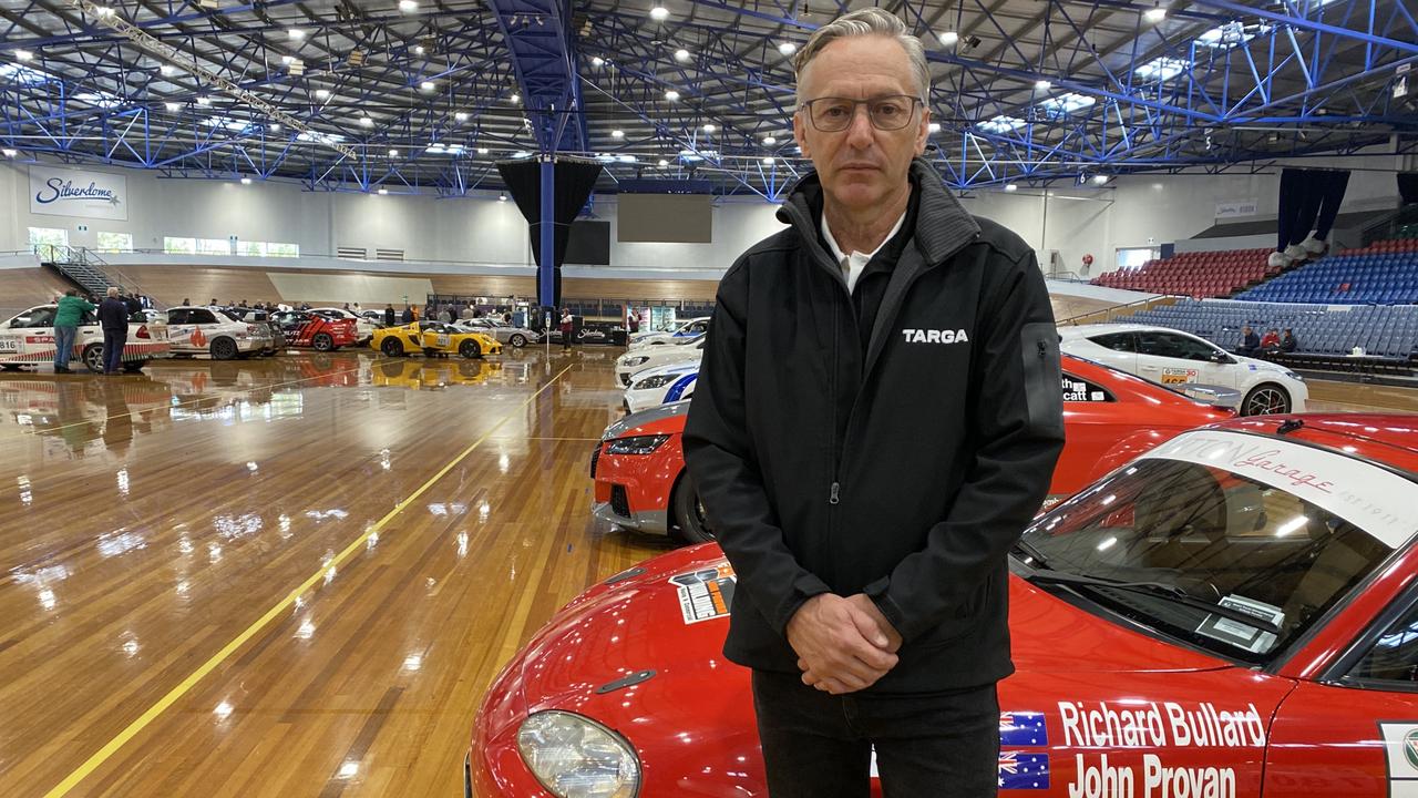 Targa Tasmania CEO Mark Perry at the Silverdome among the remaining competition cars. Picture James Bresnehan