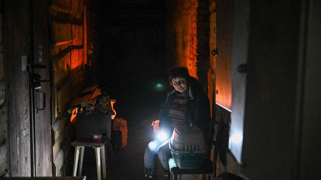 A woman sits next to a cat box in the basement of a building used as shelter during shelling in the town of Schastia near the eastern Ukraine city of Lugansk, on Tuesday. Picture: Aris Messinis / AFP