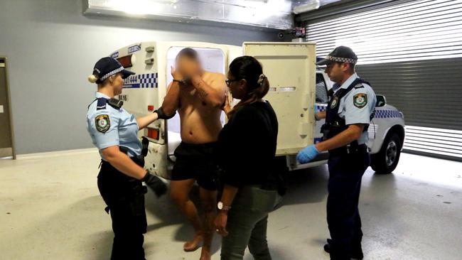 Police escort a man into custody. Picture: NSW Police