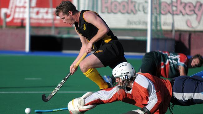 Mark Harris battles with a goalkeeper during his time playing in the Brisbane Hockey League. Photo Lee Oliver