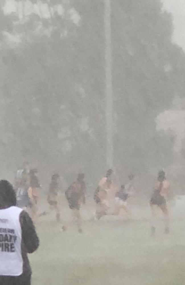 Players are hard to distinguish as rain hammers down during an EDFL girls match.