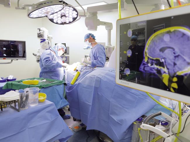 Supplied undated image obtained Wednesday, August 30, 2017 of medical professionals performing neurosurgery at the Ramsay Health Care-operated Greenslopes Private Hospital in Brisbane. Ramsay Health Care has lifted full-year net profit 8.6 per cent to $488.9 million on the back of growth in admissions and procedural volumes across the company's Australian business. The country's largest private hospital operator said revenue from services for the year to June 30 grew marginally, up 0.2 per cent, to $8.7 billion, from $8.68 billion a year ago. (Ramsay Health Care)  EDITORIAL USE ONLY