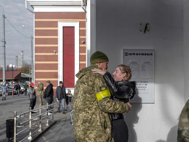 A Ukrainian soldier hugs his partner as she arrives from Kyiv, at a train station in eastern Ukraine on November 7, 2022, amid the Russian invasion of Ukraine. (Photo by BULENT KILIC / AFP)