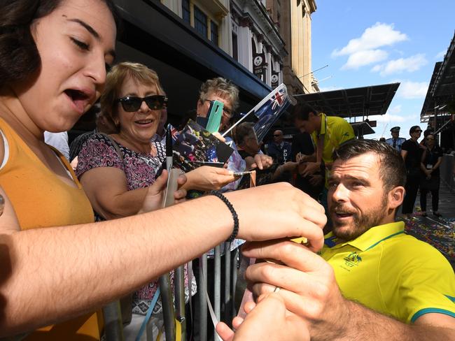 Australian wheelchair racer Kurt Fearnley shares his medals with fans during a street parade in honour of Gold Coast Commonwealth Games athletes through central Brisbane, Friday, April 27, 2018. (AAP Image/Dan Peled) NO ARCHIVING