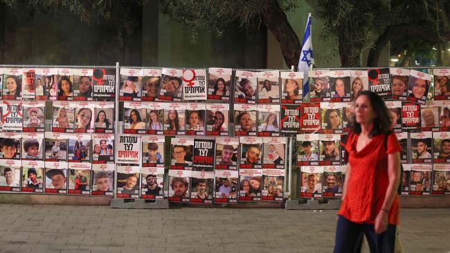 A woman walks past portraits of Israeli hostages taken by Palestinian militants in the October 7 attack during a demonstration calling for their release in Tel Aviv on Monday. Picture: AFP