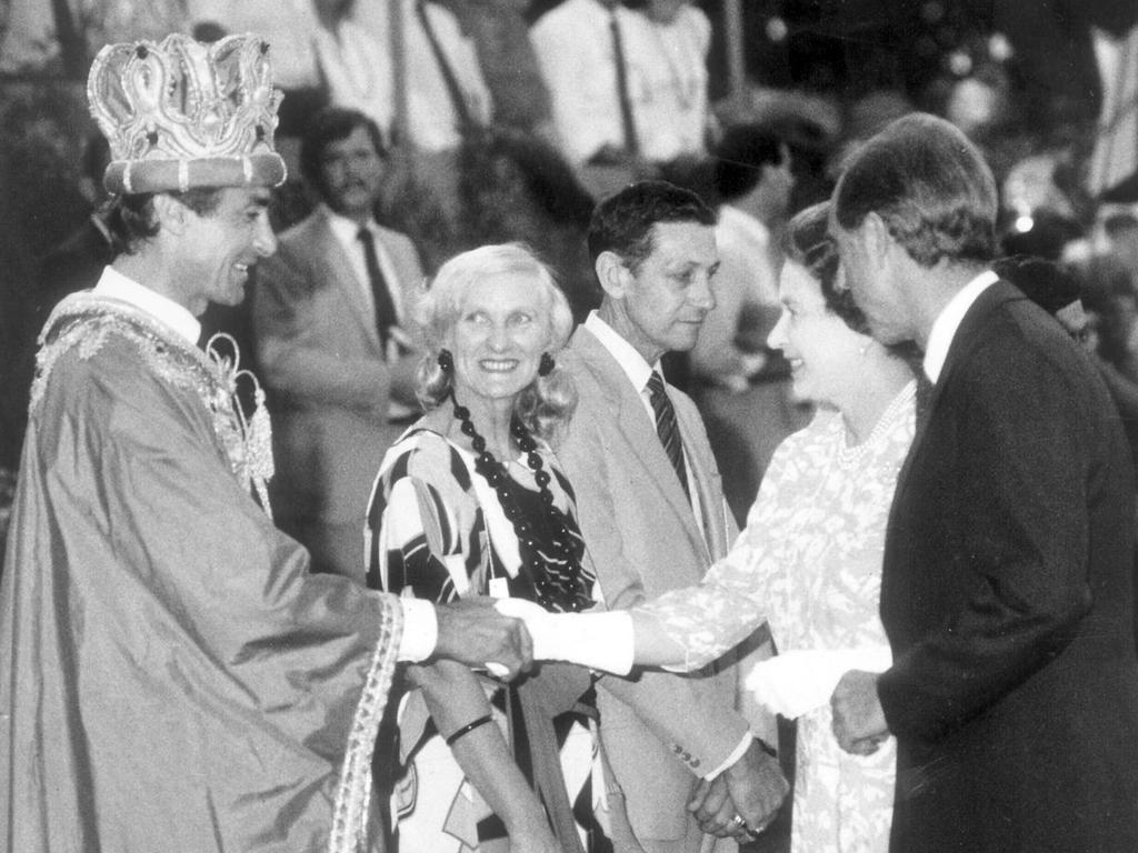 <b>1986 – Melbourne</b> The ever-stylish Queen looks almost casually dressed in comparison as she is presented to Melbourne’s 1986 King of Moomba – racing driver Peter Brock in robe and crown.