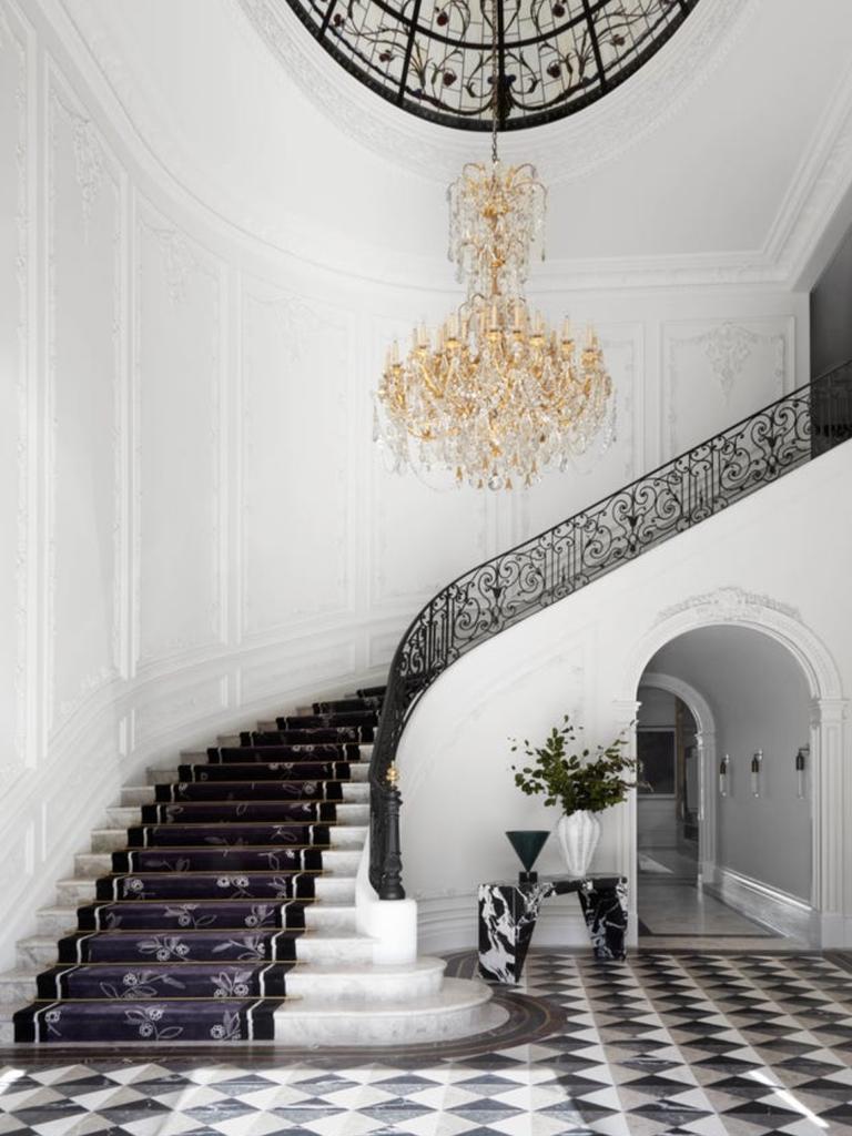 The mansion’s entrance hall impresses with its brass doors and exquisite marble flooring.