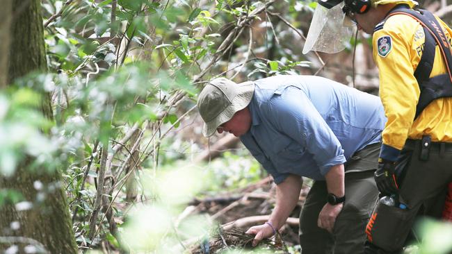 Dr Jon Olley inspects possible evidence found outside the crime scene search area. Picture: Peter Lorimer