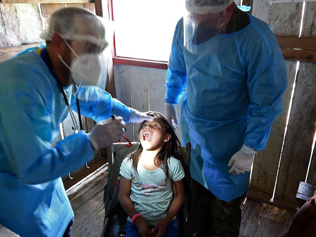 Doctors of the Brazilian Armed Forces check an indigenous child of the Mayoruna ethnic group in northern Brazil. Picture: EVARISTO SA / AFP.