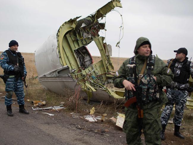 Pro-Russian gunmen stand guard as Dutch investigators (unseen) arrive near parts of the Malaysia Airlines Flight MH17 at the crash site in eastern Ukraine. Picture: AFP