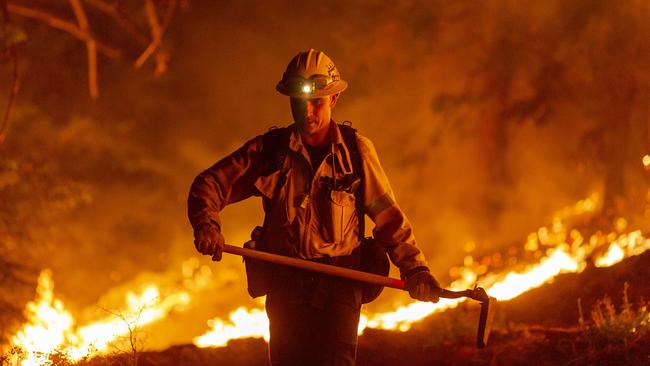 A Los Angeles County firefighter, using only hand tools, keeps fire from jumping a fire break at the Bobcat Fire in the Angeles National Forest in California Picture: Getty Images