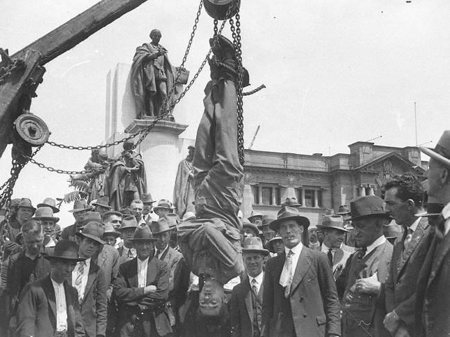 Magic Murray, the escapologist, is hauled up by his feet in a straight jacket, in 1928.