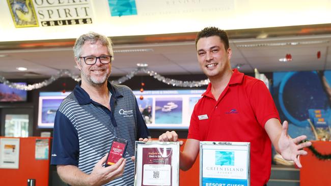 Quicksilver Group managing director Tony Baker and Reservations Supervisor Matty Gray use a QR code to check in to Green Island Resort before hopping on to the ferry. Picture: Brendan Radke