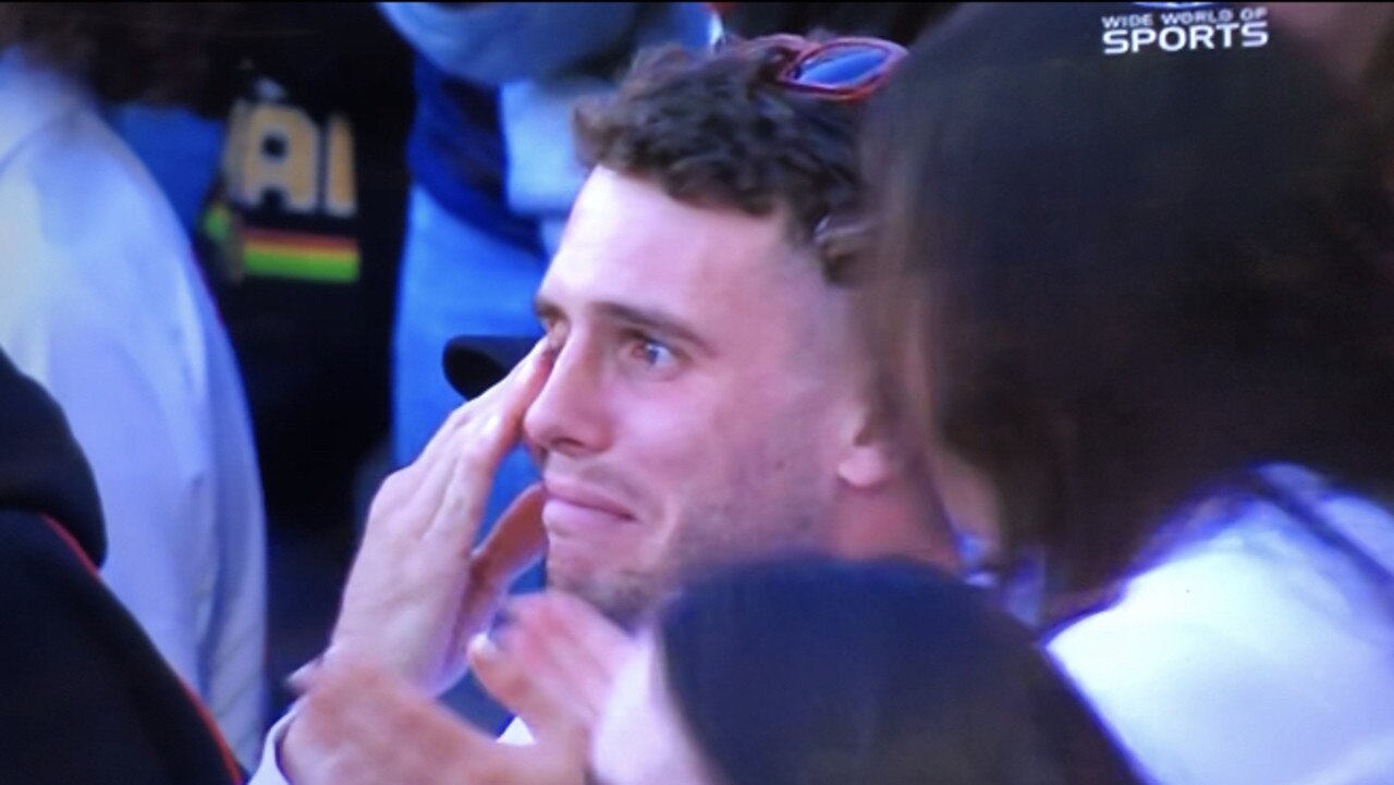 Adam Elliott in tears as he watches partner and Knights co-captain Millie Boyle speak after winning the NRLW title. Pic: Channel Nine.