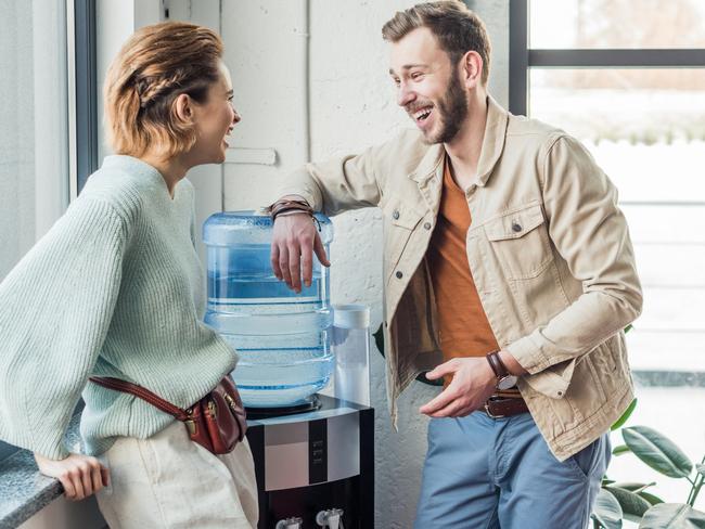 casual businessman and woman talking and laughing in loft office