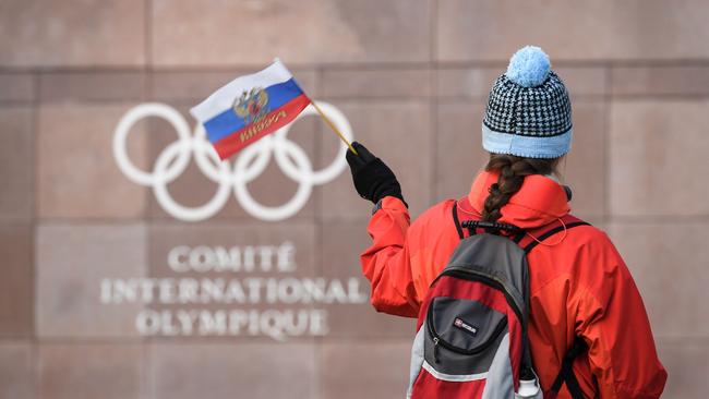 A Russia supporter waves a Russian flag in front of the International Olympic Committee (IOC) headquarters. Picture: Fabrice Coffrini/AFP