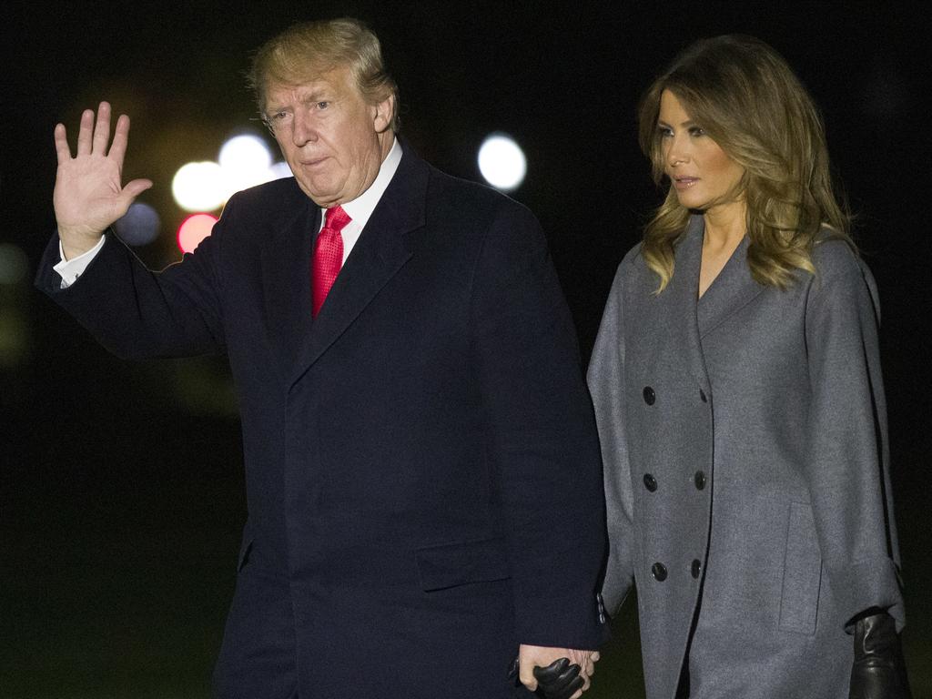 President Donald Trump waves as he walks with first lady Melania Trump, after stepping off Marine One, on the South Lawn of the White House on Sunday. Picture: AP Photo/Alex Brandon