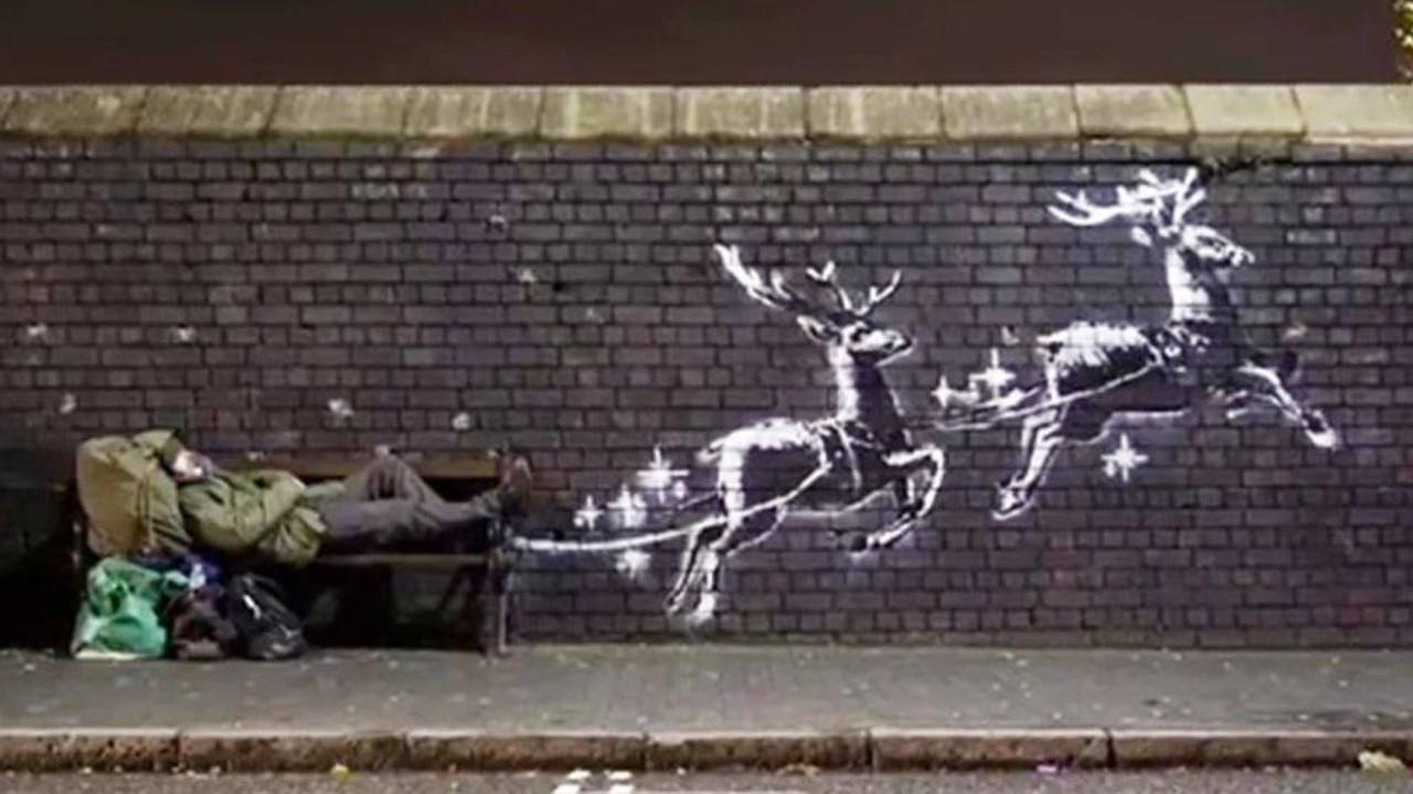 Banksy's reindeer mural in Birmingham, UK, which was filmed with a man named Ryan having a sleep on the bench. Picture: Instagram/@Banksy