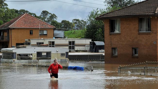 A resident fades through water in western Sydney as the area faces its equal worst flooding. Picture: Muhammad Farooq/AFP