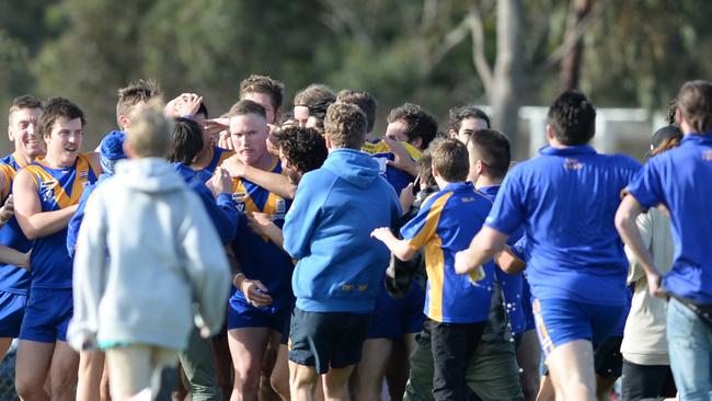 The crowd and Marc Holt’s teammates converge after his 1000th goal. Picture: Chris Eastman.