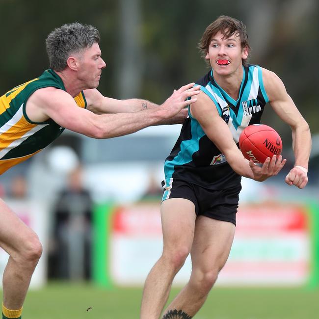 Dookie United’s Ryan McKenna handballs off to a teammate.