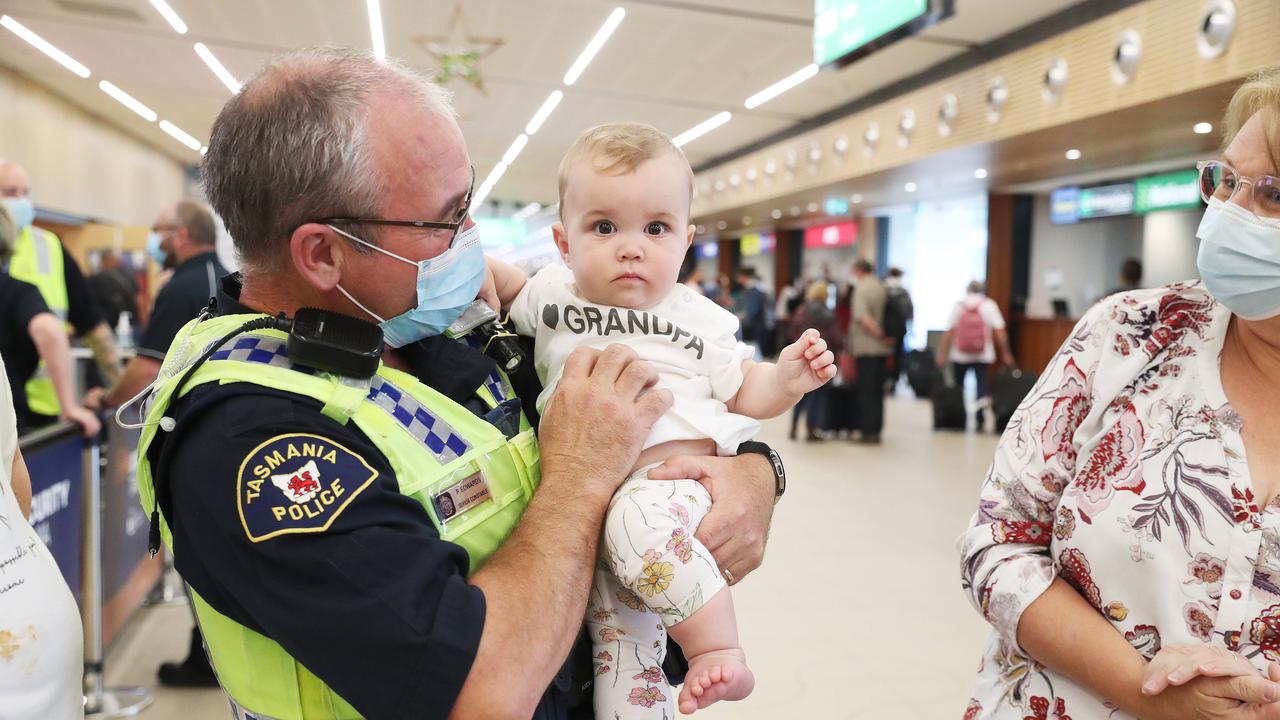 Tasmania Police Senior Constable Paul Edwards who was working at the airport on day 1 of border reopening reunited with granddaughter Isla 7 months from Newcastle who have been separated since she was 4 weeks old. Picture: Nikki Davis-Jones