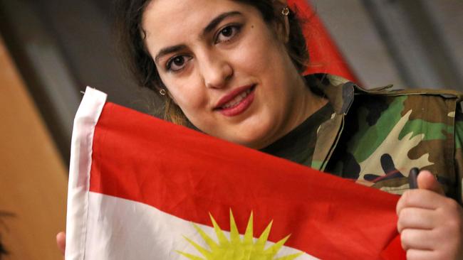 A female member of a Kurdish Peshmerga battalion holds a Kurdish flag as she waits to cast her vote in the Kurdish independence referendum at a polling station in Arbil on September 25, 2017. Picture: AFP / SAFIN HAMED