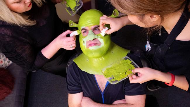 Make-up artists skilfully blending the green face paint with the prosthetics. Picture: Mark Stewart