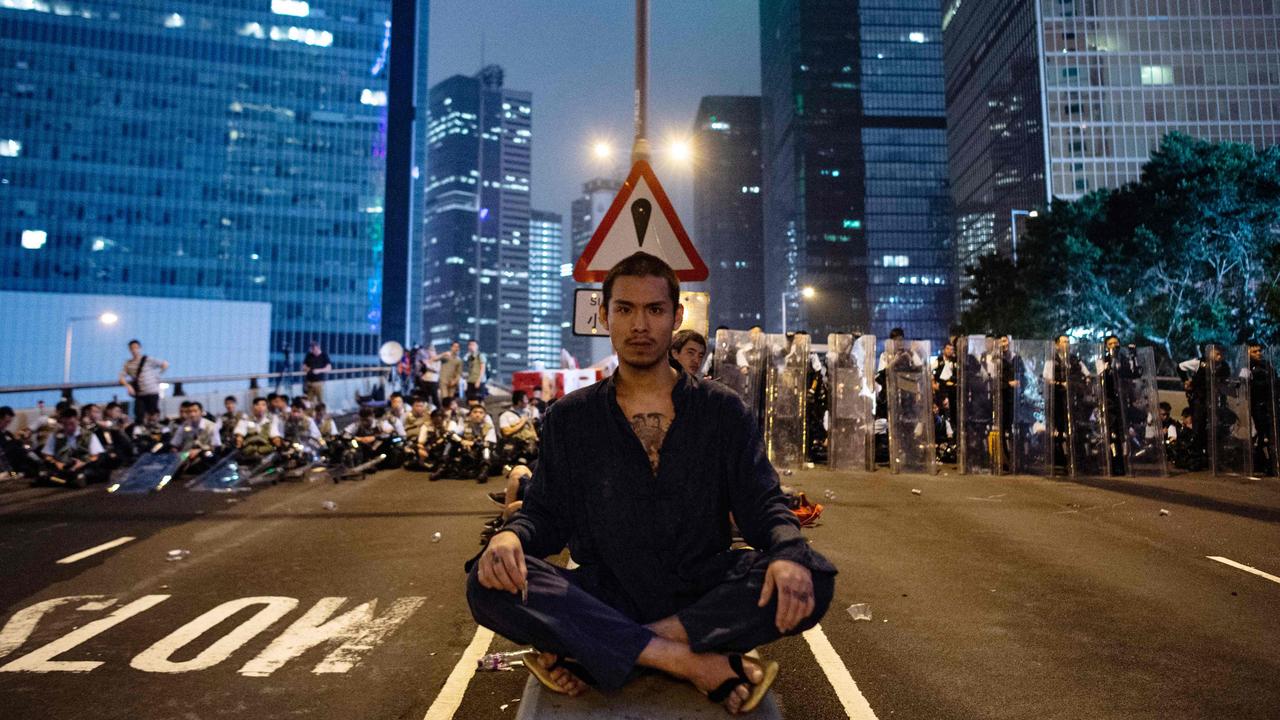 A protester sits at the middle of Harcourt Road in Hong Kong after a protest against a controversial extradition law proposal in Hong Kong on June 12, 2019.