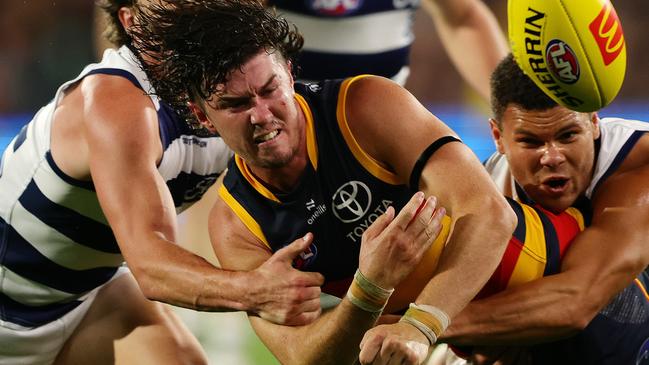 ADELAIDE, AUSTRALIA - MARCH 22: Ned McHenry of the Crows under pressure from Gryan Miers of the Cats and Brandan Parfitt of the Cats during the 2024 AFL Round 2 match between the Adelaide Crows and the Geelong Cats at Adelaide Oval on March 22, 2024 in Adelaide, Australia. (Photo by Sarah Reed/AFL Photos via Getty Images)