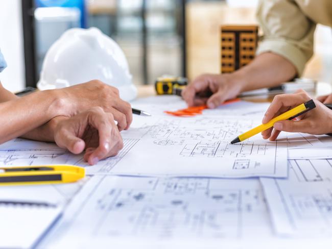 Image of team engineer checks construction blueprints on new project with engineering tools at desk in office.