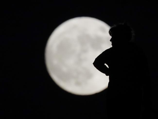 A woman is silhouetted against the moon while walking her dog Sunday, Nov. 13, 2016, in La Habra, Calif. Monday’s so-called supermoon will be the closest the moon comes to us in almost 69 years. And it won’t happen again for another 18 years. Picture: AP Photo/Jae C. Hong