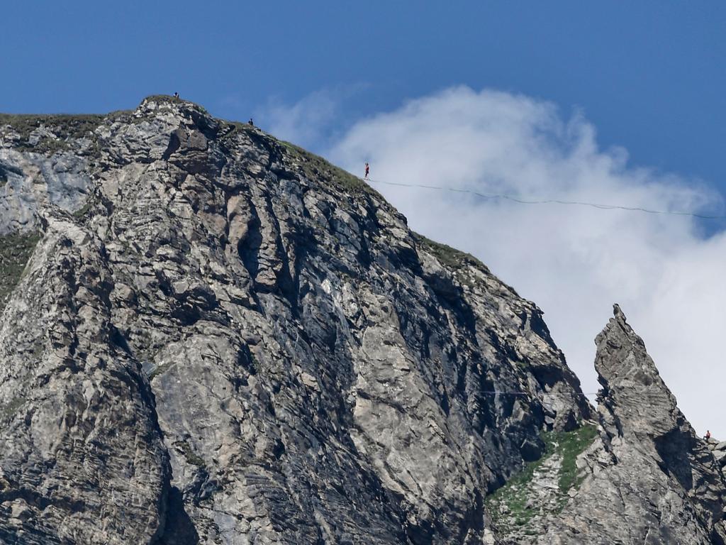 A man performs tightrope walking near the Cormet de Roselend along the route of the eleventh stage of the 105th edition of the Tour de France cycling race between Albertville and La Rosiere, French Alps, on July 18, 2018. / AFP PHOTO / Philippe LOPEZ
