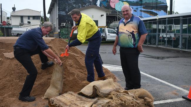 Hinchinbrook Shire Council employees Chris Johnson, the acting head of engineering services, and Luke Argent, roads manager, fill sandbags for elderly or disabled members of the community. Mayor Ramon Jayo (right) says BOM has issued a severe weather warning as a low system continues to strike North Queensland. Picture: Cameron Bates