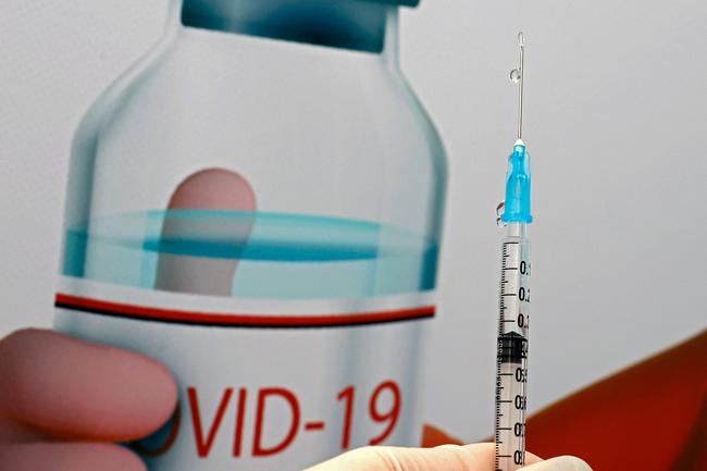 A COVID-19 vaccine is seen outside an advertisement for vaccines. Picture: AFP