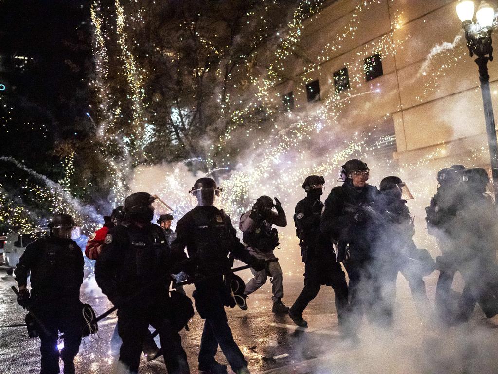 A firecracker explodes behind their police line. Picture: Nathan Howard/Getty Images/AFP