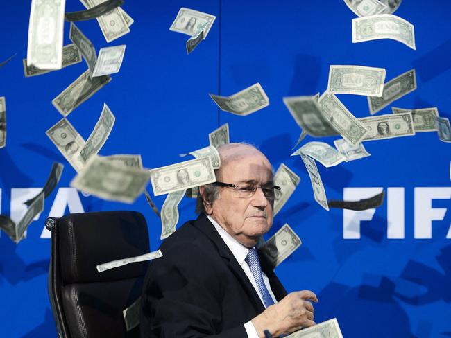 (FILES) In this file photo taken on July 20, 2015 FIFA president Sepp Blatter looks on as fake dollar notes fly around him, thrown by a British comedian during a press conference at the FIFA world-body headquarter's in Zurich. - Former FIFA president Sepp Blatter says the decision to award the 2022 World Cup finals to Qatar was a 