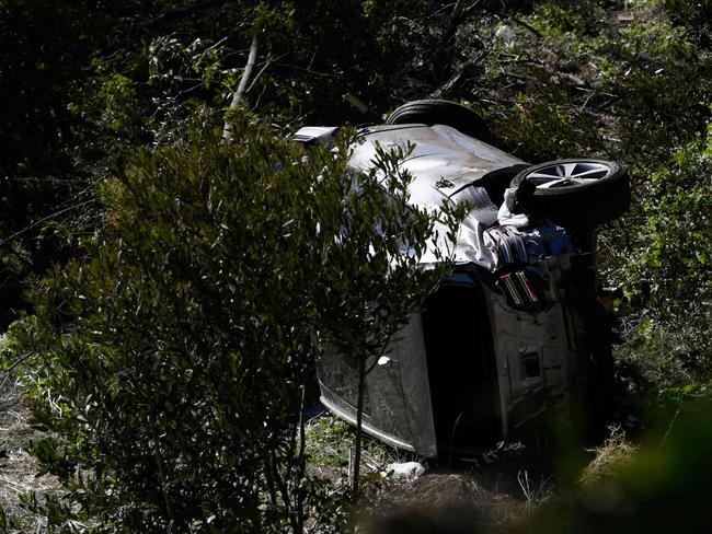 The vehicle driven by golfer Tiger Woods lies on its side in Rancho Palos Verdes, California, on February 23, 2021, after a rollover accident. - US golfer Tiger Woods was hospitalized Tuesday after a car crash in which his vehicle sustained "major damage," the Los Angeles County Sheriff's department said. Woods, the sole occupant, was removed from the wreckage by firefighters and paramedics, and suffered "multiple leg injuries," his agent said in a statement to US media. (Photo by Patrick T. FALLON / AFP)