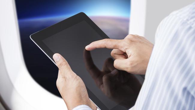 Businessman holding digital tablet in airplane