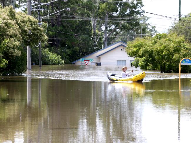 Sam Jolley uses a boat to get around Oxley on Monday. Picture: Steve Pohlner