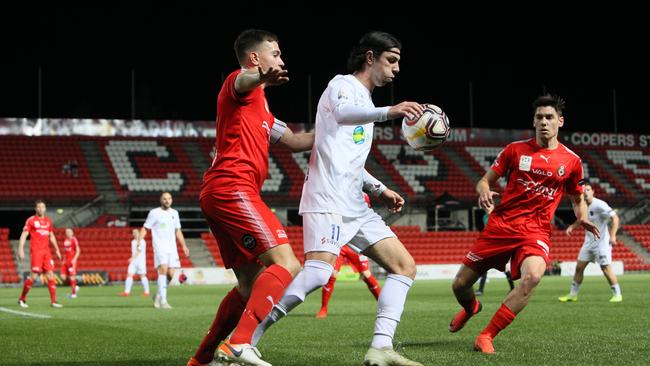 Comets player Jayden Lobasso under pressure from Campbelltown’s Joel Allwright and acting captain Shaun Harvey at Hindmarsh Stadium on Saturday night. Picture: AAP/Emma Brasier