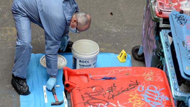 A forensic officer with the hammer they found, believed to have been Mr Dick’s. Picture: Andrew Henshaw