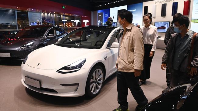 People look at Tesla Model 3 cars in a Tesla showroom in Beijing last month. Picture: AFP