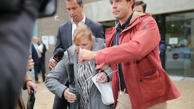 Dale Palmer emerged from court, shielded by her son (red coat). Picture: NCA NewsWire / Christian Gilles