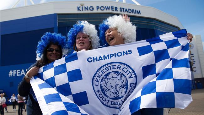 Leicester city fans celebrate outside the King Power Stadium in Leicester, central England, on May 3, 2016, after the team won the English Premier League on Monday May 2. Thousands celebrated and millions around the world watched in wonder as 5,000-1 underdogs Leicester City completed arguably the greatest fairytale in sporting history by becoming English Premier League champions yesterday. Second-placed Tottenham Hotspur's 2-2 draw at Chelsea late on Monday was enough for last year's relegation battlers Leicester to seal a scarcely credible title after outshining some of football's most glamorous teams. / AFP PHOTO / JUSTIN TALLIS